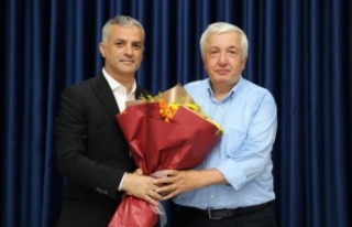 Başkan bıyık prof. Dr okuyana çiçeğini takdim...